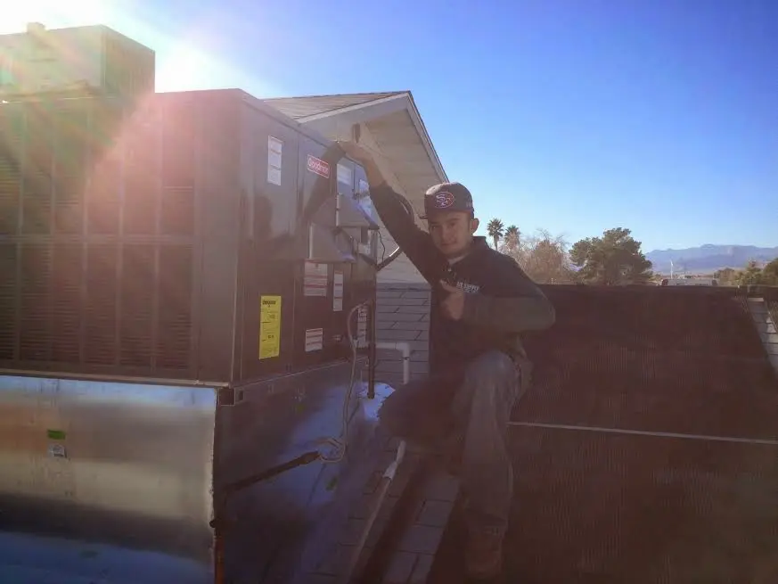 HVAC technician performing Air Duct Cleaning on a rooftop unit in Sun Valley